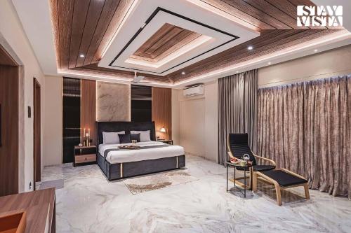a bedroom with a king sized bed and a chair at StayVista at Grande Prima - Pool, Theatre Room & BBQ in Panchgani