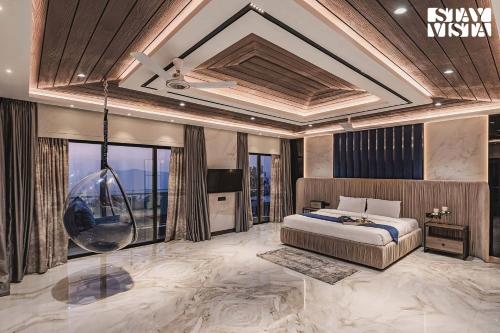 a bedroom with a king sized bed and large windows at StayVista at Grande Prima - Pool, Theatre Room & BBQ in Panchgani