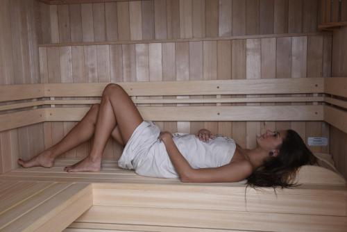 a woman is laying in a sauna at Living Nature Appartements in San Vigilio Di Marebbe