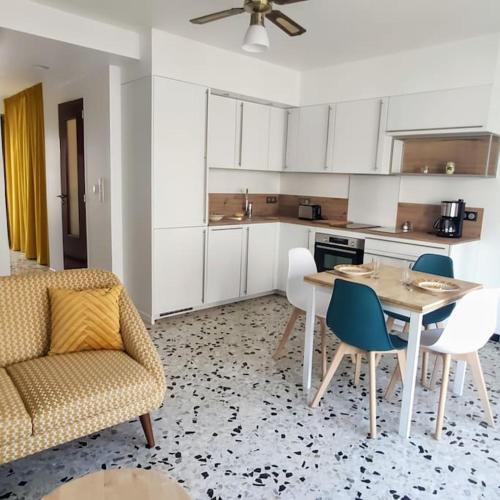 une cuisine avec une table, des chaises et un canapé dans l'établissement Le Perroquet Appart' aux Sablettes plage parking, à La Seyne-sur-Mer