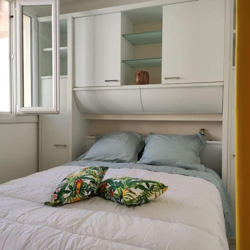 un lit avec deux oreillers dessus dans une chambre dans l'établissement Le Perroquet Appart' aux Sablettes plage parking, à La Seyne-sur-Mer