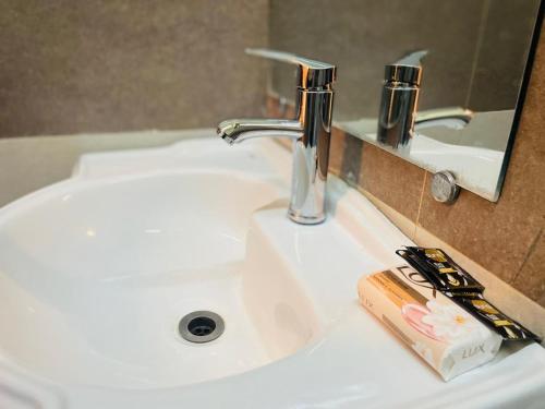 ein Waschbecken mit Wasserhahn und eine Zahnbürste in der Unterkunft Blue Moon Residency in Islamabad