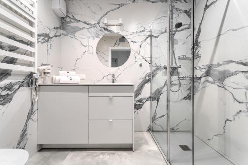 une salle de bain avec une vanité blanche et un miroir dans l'établissement Sea & Lake - City Apartments, à Mielno