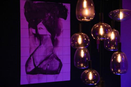 a painting of a woman with lights on a wall at 7eme loft in Saint-Victor-de-Cessieu
