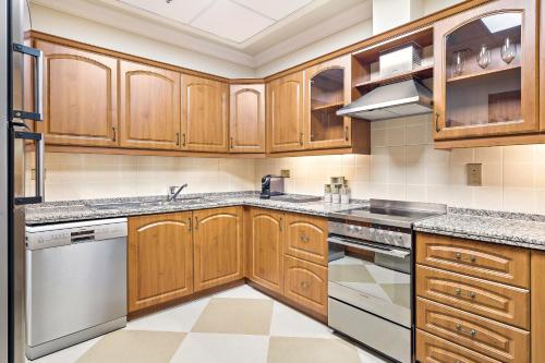 a kitchen with wooden cabinets and stainless steel appliances at Kempinski Hotel & Residences Palm Jumeirah in Dubai