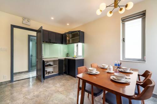 a dining room with a table and a kitchen at Full Moon Apartments & Villa - Hoi An in Hoi An