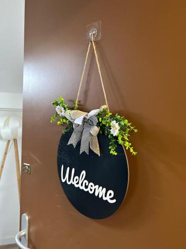 a welcome sign hanging on a wall with flowers at Superbe T2 meublé hyper centre in Thonon-les-Bains