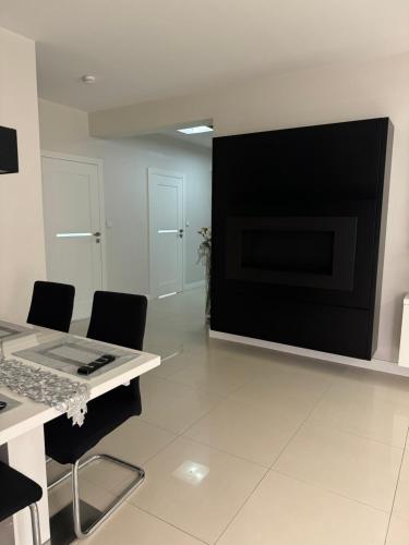 a living room with a tv and a table and chairs at Spanko w centrum in Zielona Góra