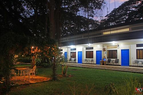 a house with blue doors and a person in the yard at Ponce De Leon Garden Resort Powered by ASTON in San Miguel