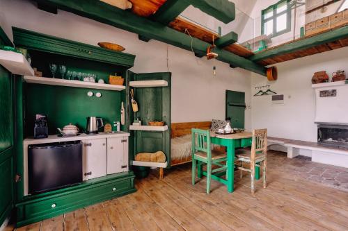 a kitchen with green cabinets and a table and a tv at Echoes of Vlădicu in Cluj-Napoca
