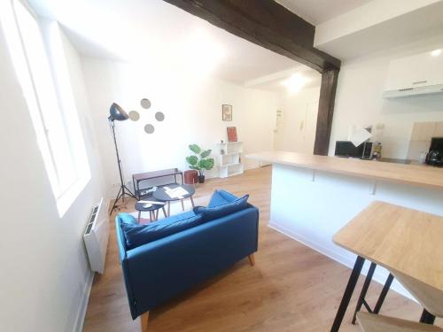 un salon avec un canapé bleu et une table dans l'établissement L'Eclipse Amboisienne - Appart. 2 pers., à Amboise