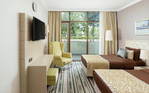 a hotel room with two beds and a chair at Gashalti Health Hotel Naftalan in Naftalan