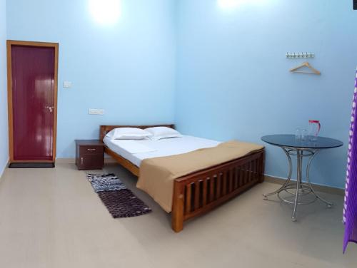 a bedroom with a bed and a table in a room at Travelmate Vagamon in Vagamon