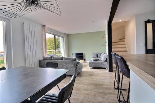 une salle à manger et un salon avec une table et des chaises dans l'établissement Maison de Vacances avec Vue sur mer - NAUSICAA, à Boulogne-sur-Mer