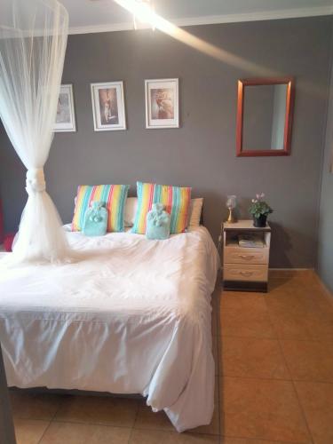 a bedroom with a bed with two stuffed animals on it at Addo's Secret Backdoor in Gqeberha