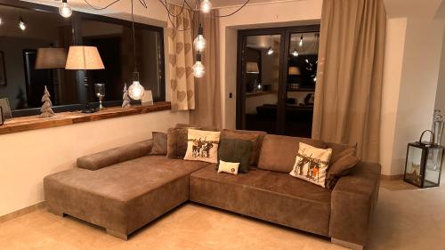 a brown couch in a living room with a mirror at Lou Garden Suite in Auland
