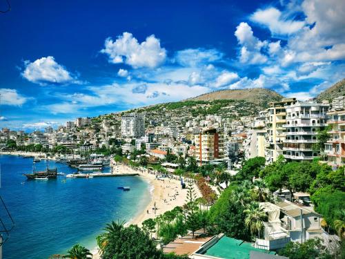 uitzicht op een strand in een stad met gebouwen bij Lida's Seafront Apartments in Sarandë