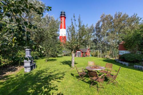 a red and white lighthouse with a table and chairs at Austernfischer Haus in Pellworm