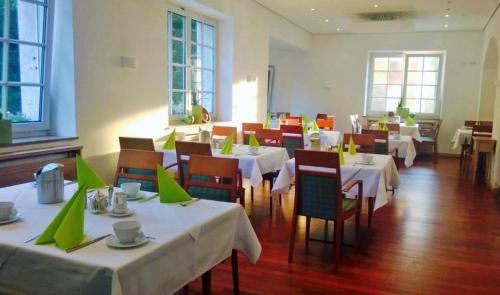 a restaurant with tables and chairs with green napkins on them at Bad Hotel Bad Überkingen in Bad Überkingen