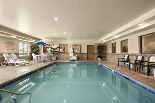 a large swimming pool with chairs and a table at Country Inn & Suites by Radisson, Minot, ND in Minot