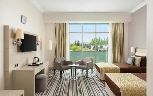 a hotel room with a bed and a desk and a table at Gashalti Health Hotel Naftalan in Naftalan
