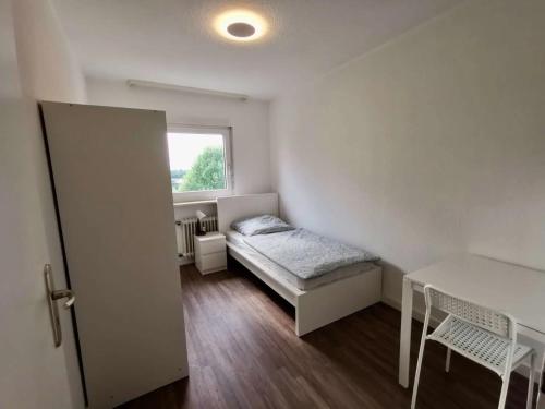 una piccola camera da letto con un letto e una finestra di Großzügige Monteurwohnung mit TOP Anbindung a Bensheim