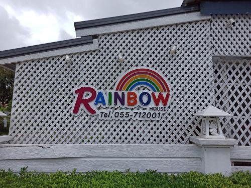 un cartello arcobaleno sul lato di un edificio di RainBow House Resort a Kamphaeng Phet