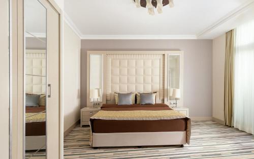 a bedroom with a large bed and a mirror at Gashalti Health Hotel Naftalan in Naftalan