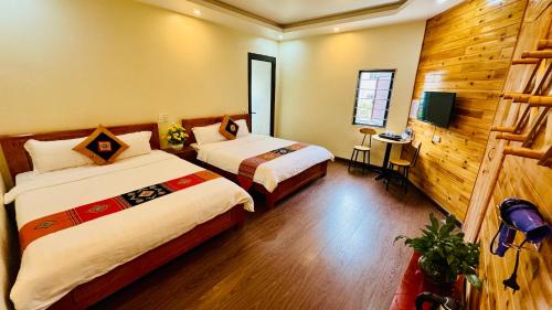 a hotel room with two beds and a television at Sapa Harmony Homestay in Sapa