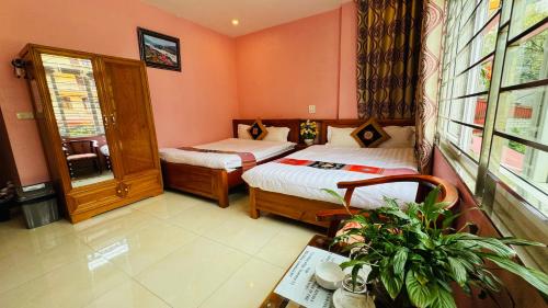 a bedroom with two beds and a table with a plant at Sapa Harmony Homestay in Sapa