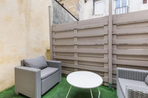 a patio with two chairs and a table and a fence at Studio en Duplex-Aircon-Terrasse-Parking-Calme in Bordeaux