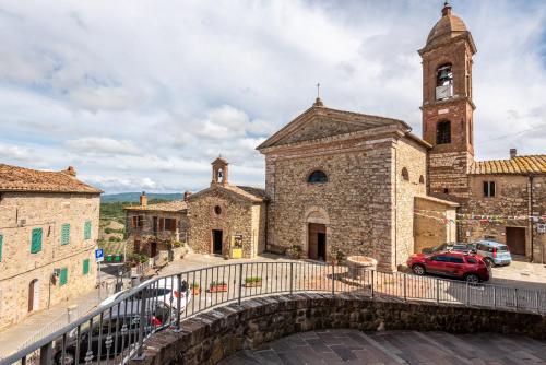 a stone church with a clock tower and a bridge at Sotto gli archi in Pari