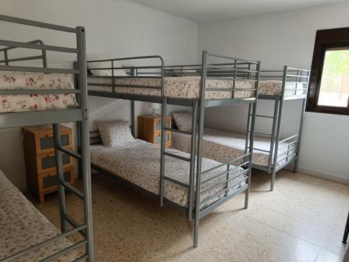 a room with three bunk beds in a room at La Jaima in Prado del Rey