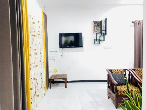 a living room with a tv on a wall at Peacock Villa in Welihinda