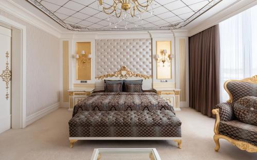 a bedroom with a large bed and a chandelier at Gashalti Health Hotel Naftalan in Naftalan