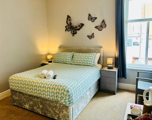 a bedroom with a bed with butterflies on the wall at Le Papillon Hotel Blackpool in Blackpool