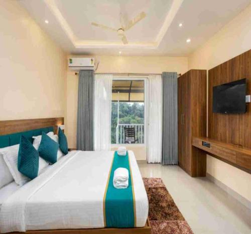 a bedroom with a large bed and a flat screen tv at Le Serene Munnar Luxury Resorts & Spa in Ūdumbanshola