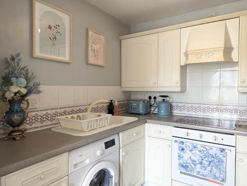 a kitchen with a sink and a washing machine at City Centre Vintage Theme Guest Rooms Free Parkin in Liverpool