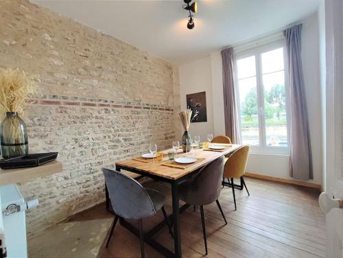 une salle à manger avec une table et des chaises en bois dans l'établissement Caen au fil de l'eau, à Caen