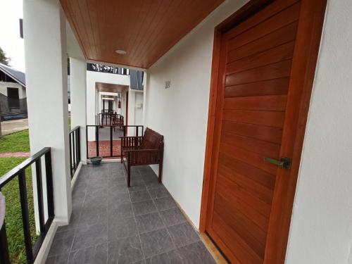 un corridoio con una porta di legno in una casa di RainBow House Resort a Kamphaeng Phet