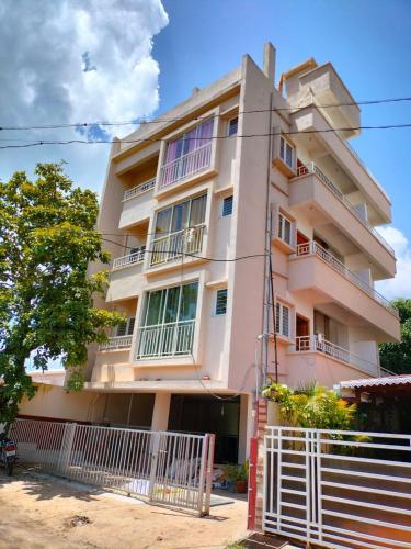a building with a white fence in front of it at The Peace Home SRUSHTI AC for Master Bedroom in Kolhapur