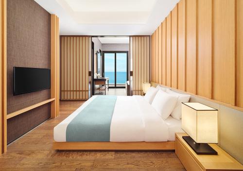 a hotel room with a bed and a television at Hanwha Resort Geoje Belvedere in Geoje 