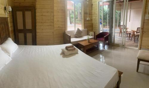 a bedroom with a white bed and a living room at The Mild Goa in Patnem