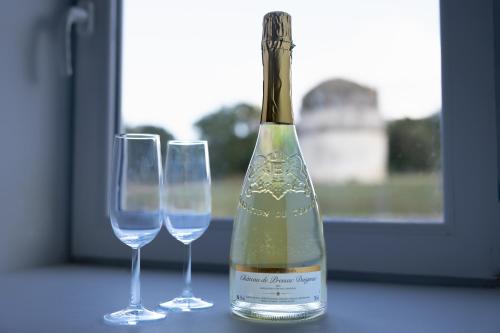 - une bouteille de vin à côté de deux verres dans l'établissement Gite De Charme - Daignac, à Daignac
