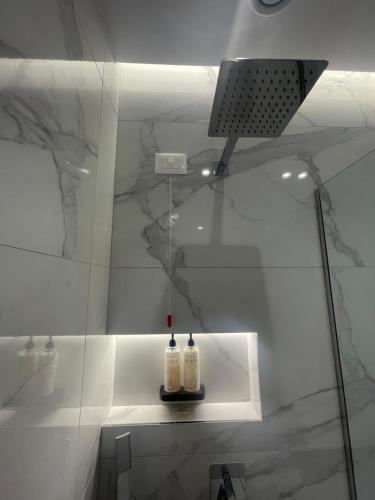a bathroom with a shower with two bottles on a shelf at Seaside Hotel in Vlorë