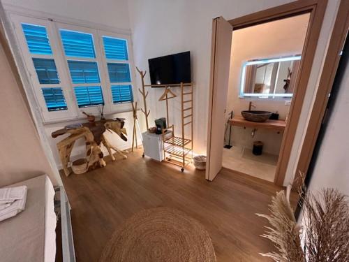 a living room with a mirror and a table and a television at Rada room&suite in Favignana
