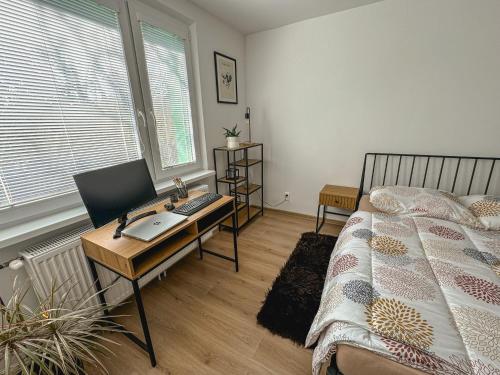 a bedroom with a desk with a computer and a bed at Fisherman's AREA 4-Room Large Apartment in Šamorín