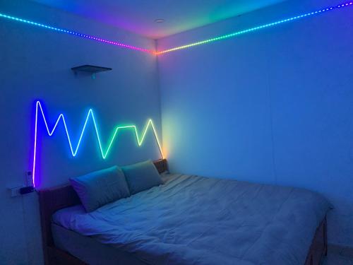 a bedroom with a bed with a neon sign on it at X-Stay Thư Trung in Hai Phong