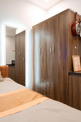 a bedroom with wooden cabinets and a bed at X-Stay Thư Trung in Hai Phong