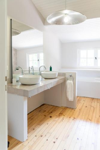 une salle de bain avec deux lavabos et un grand miroir dans l'établissement Moulin de Cazaux-Savès, à Cazaux-Savès